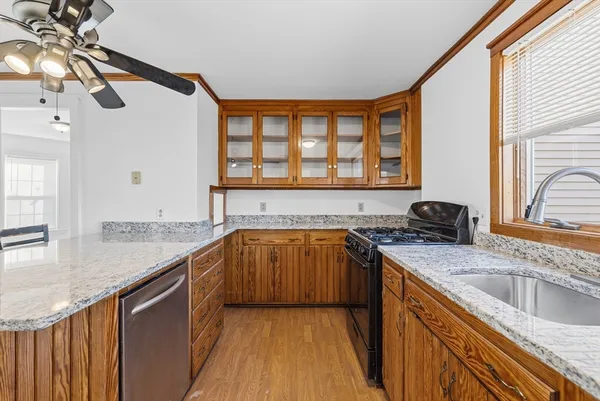 a kitchen with stainless steel appliances granite countertop a sink a stove and a wooden floors