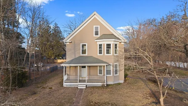 a front view of a house with a yard and green space