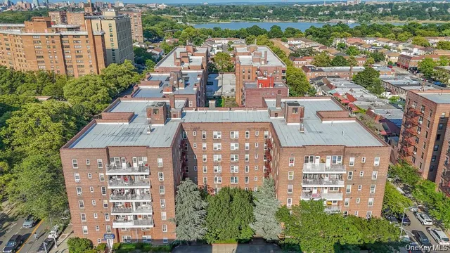 an aerial view of a residential apartment building with a yard and parking spaces