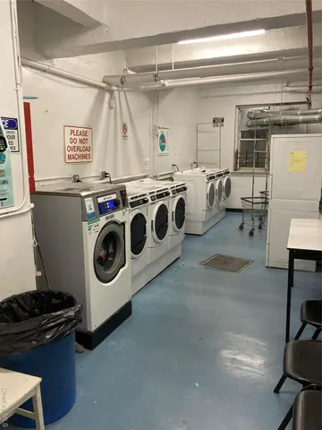 a view of a hallway with two chairs and a refrigerator