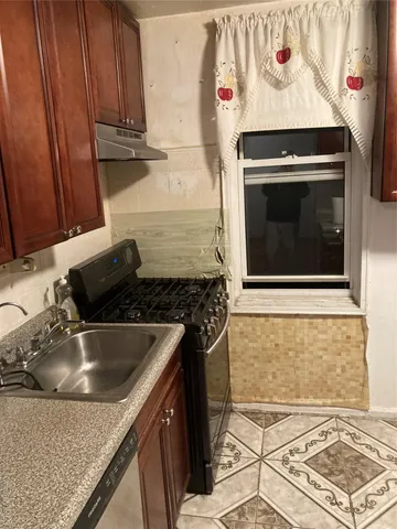 a kitchen with granite countertop wood cabinets and stainless steel appliances
