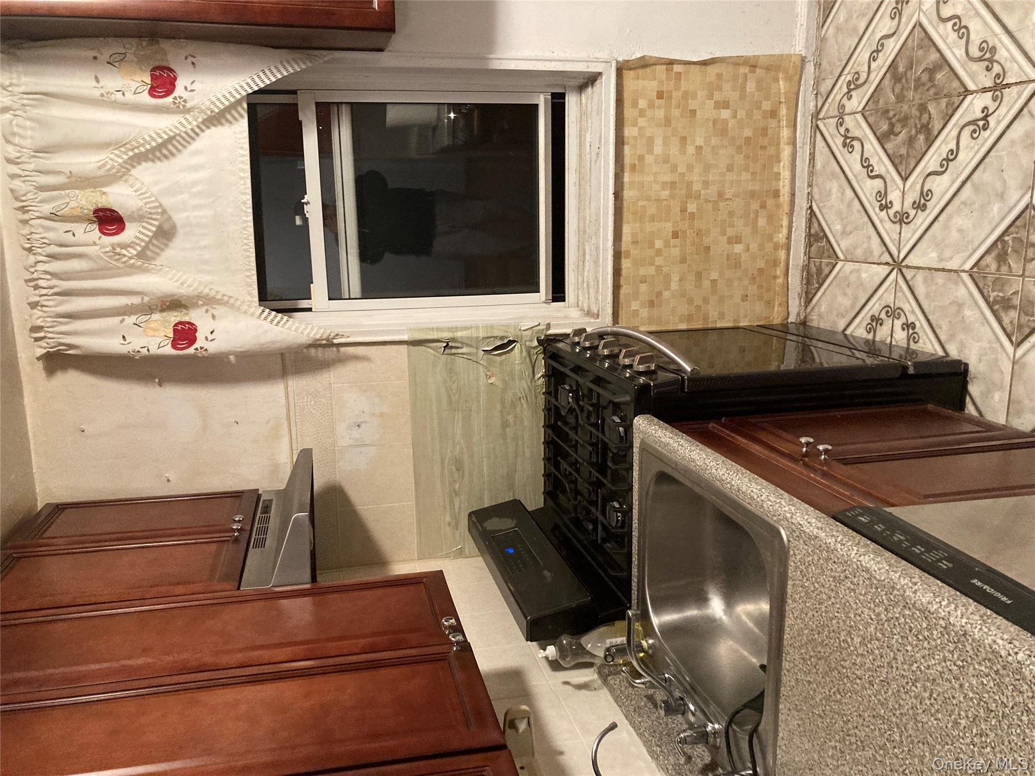 62-59 108th Street, Unit 6E Queens, NY 11375 - Photo 7 of 14 a kitchen with granite countertop a sink and a stove top oven