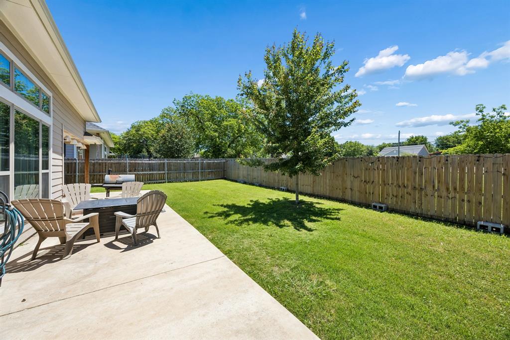 612 Frisco Road Sherman, TX 75090 - Photo 23 of 25 Expansive backyard featuring a concrete patio, mature tree, and full privacy fencing