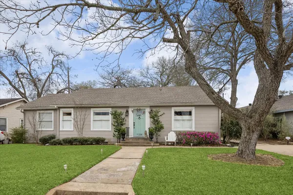 a front view of a house with a garden and yard