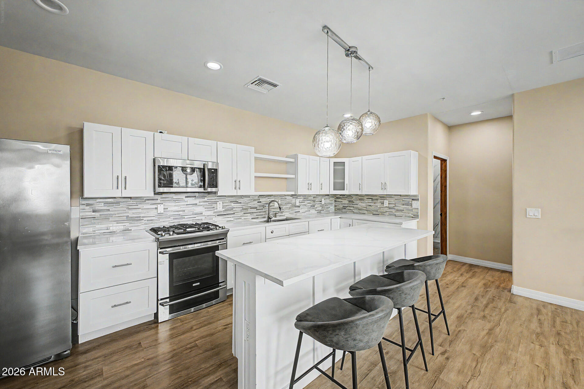 2311 East Colter Street Phoenix, AZ 85016 - Photo 53 of 93 a large kitchen with granite countertop a stove a sink a center island and wooden floor