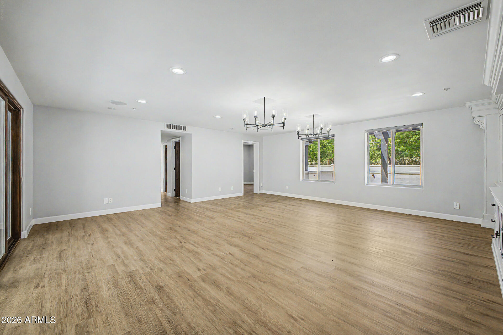 2311 East Colter Street Phoenix, AZ 85016 - Photo 6 of 93 an empty room with wooden floor and windows