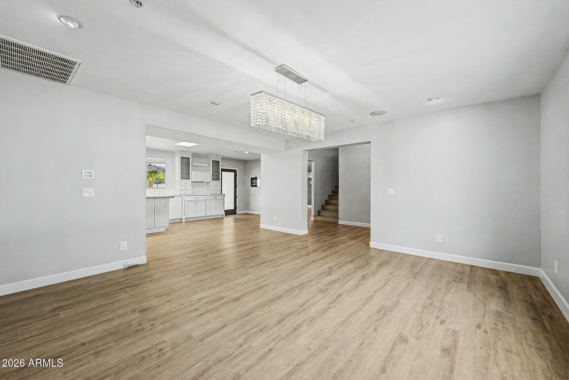 2311 East Colter Street Phoenix, AZ 85016 - Photo 10 of 93 a view of empty room with wooden floor and kitchen