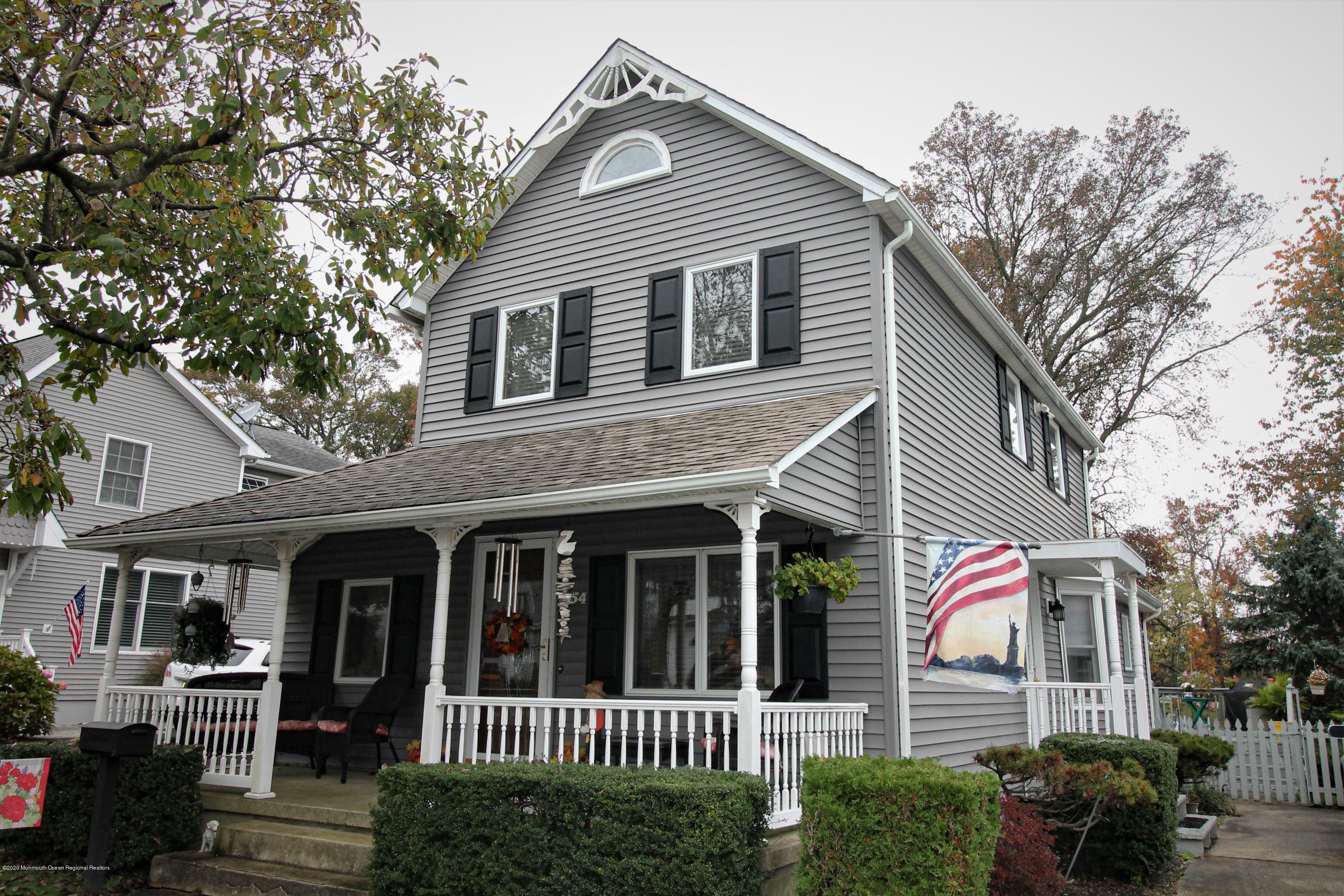 54 Ridge Avenue Manasquan, NJ 08736 - Photo 1 of 42 a view of a white house with a small yard and plants
