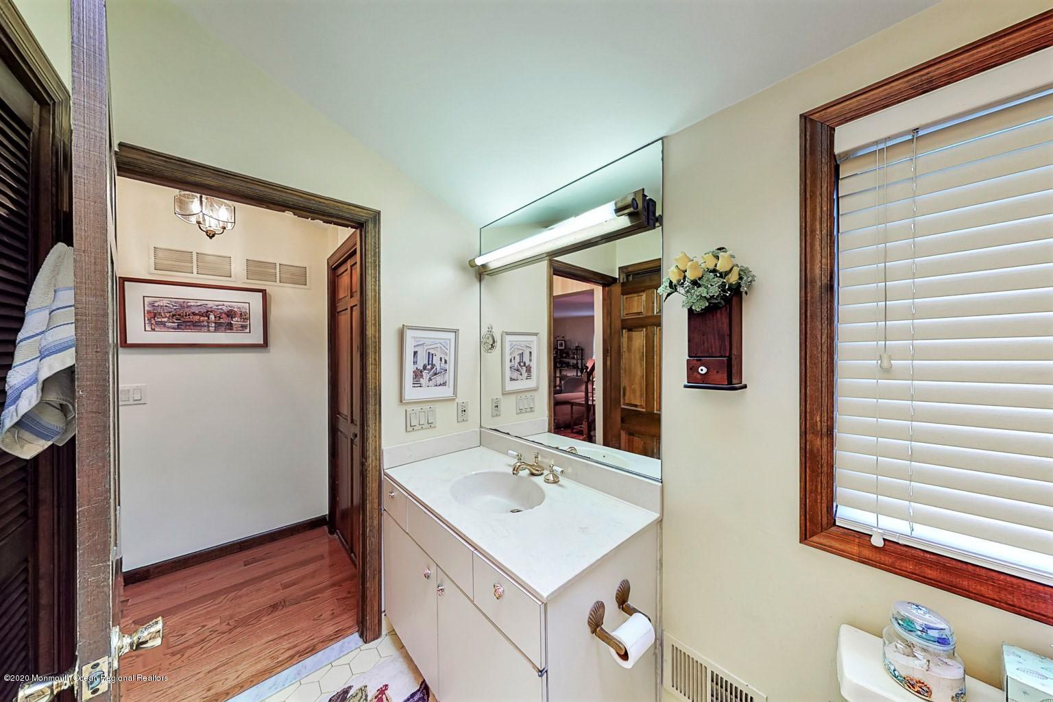 54 Ridge Avenue Manasquan, NJ 08736 - Photo 19 of 42 a bathroom with a sink a mirror and a shower