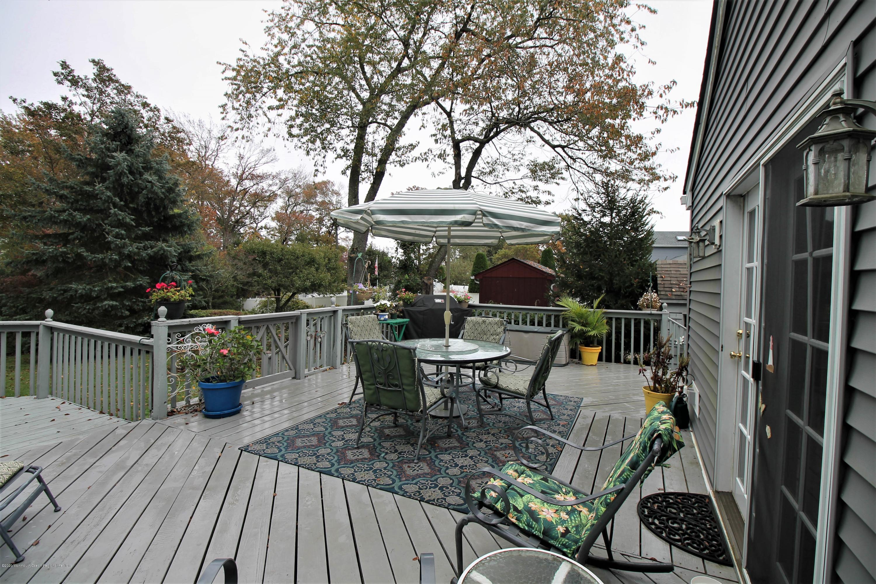 54 Ridge Avenue Manasquan, NJ 08736 - Photo 36 of 42 a view of a roof deck with table and chairs potted plants with wooden floor and fence