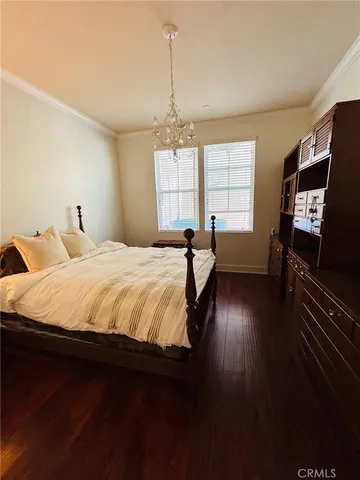 a spacious bedroom with a bed and wooden floor