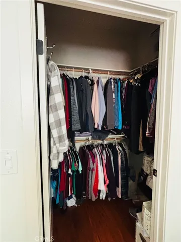 a view of walk in closet with clothes