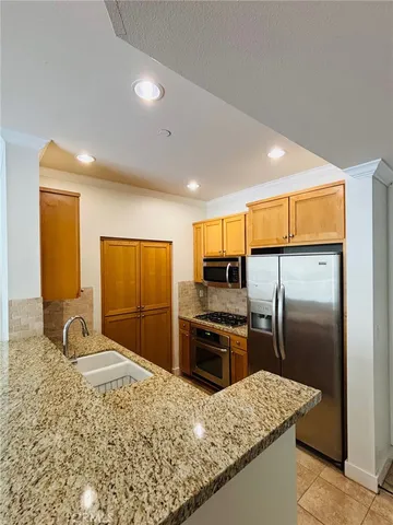a kitchen with granite countertop a refrigerator and a sink