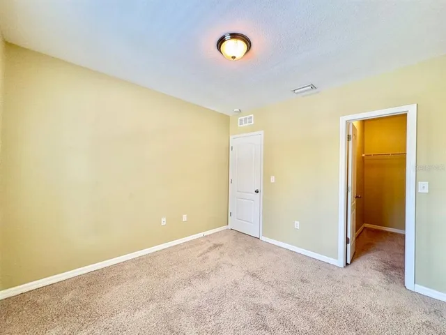 an empty room with a fan and mirror