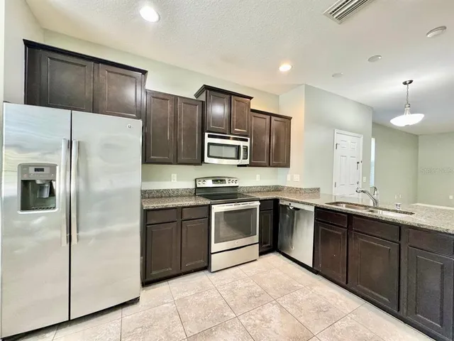 a large kitchen with cabinets and stainless steel appliances