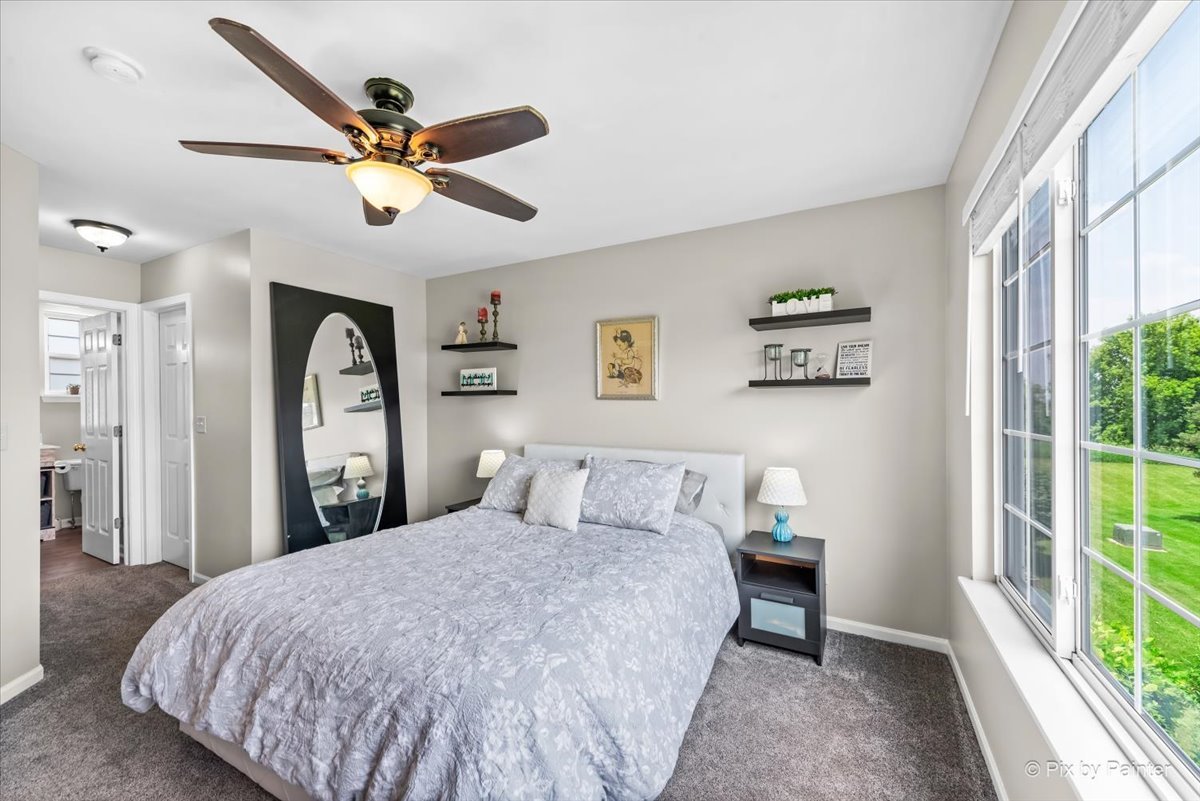 10884 Cape Cod Lane Huntley, IL 60142 - Photo 13 of 22 a bedroom with a large bed and a chandelier