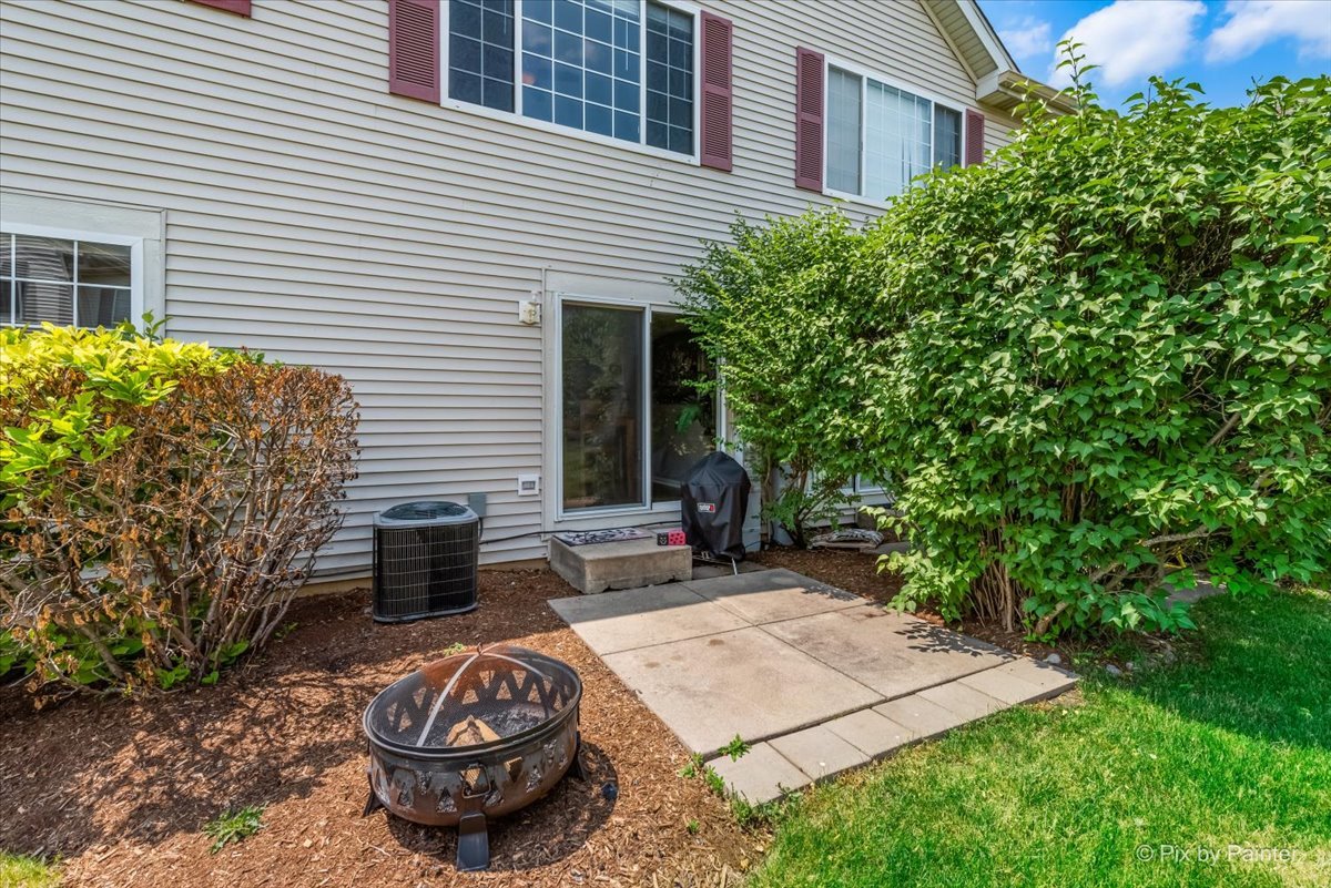 10884 Cape Cod Lane Huntley, IL 60142 - Photo 22 of 22 a view of a backyard with table and chairs and potted plants