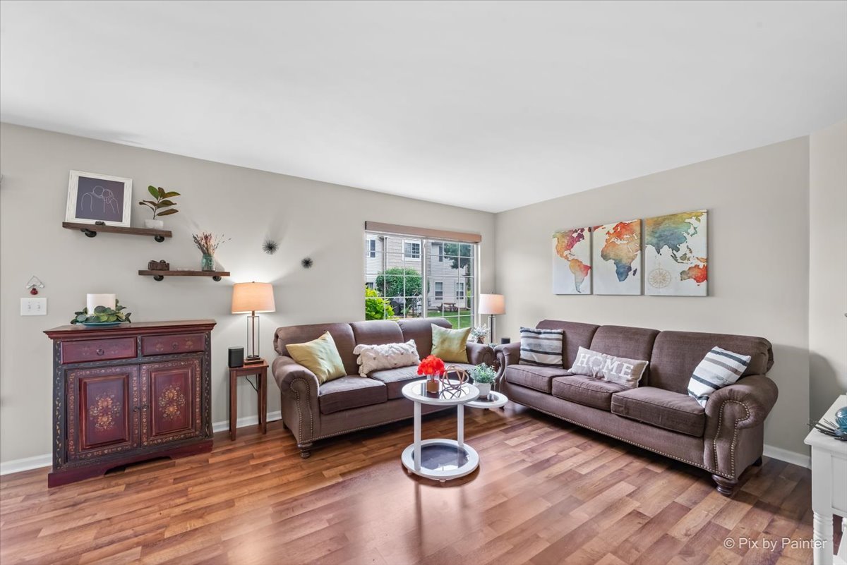 10884 Cape Cod Lane Huntley, IL 60142 - Photo 6 of 22 a living room with furniture a rug and wooden floor