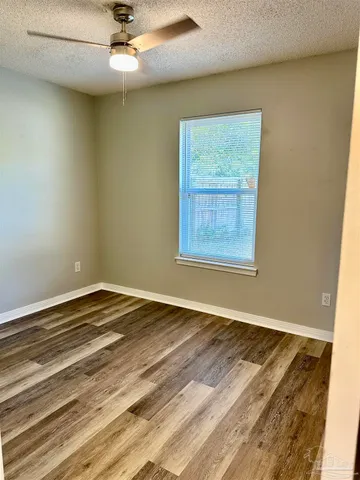 an empty room with a window and ceiling fan
