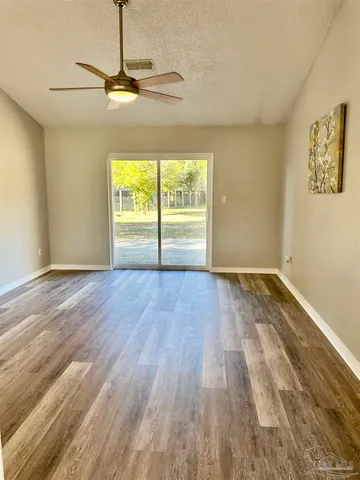 a view of room with window ceiling fan and hardwood floor