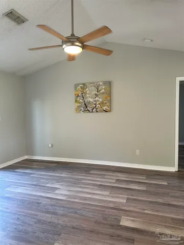 a view of a small space with wooden floor and a ceiling fan