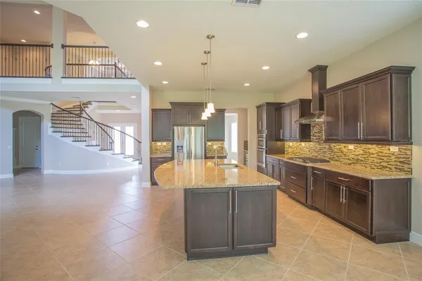 a kitchen with kitchen island a counter top space stainless steel appliances and cabinets