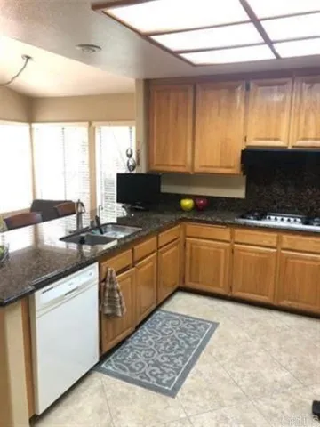 a kitchen with stainless steel appliances kitchen island granite countertop a sink a stove a counter space and cabinets