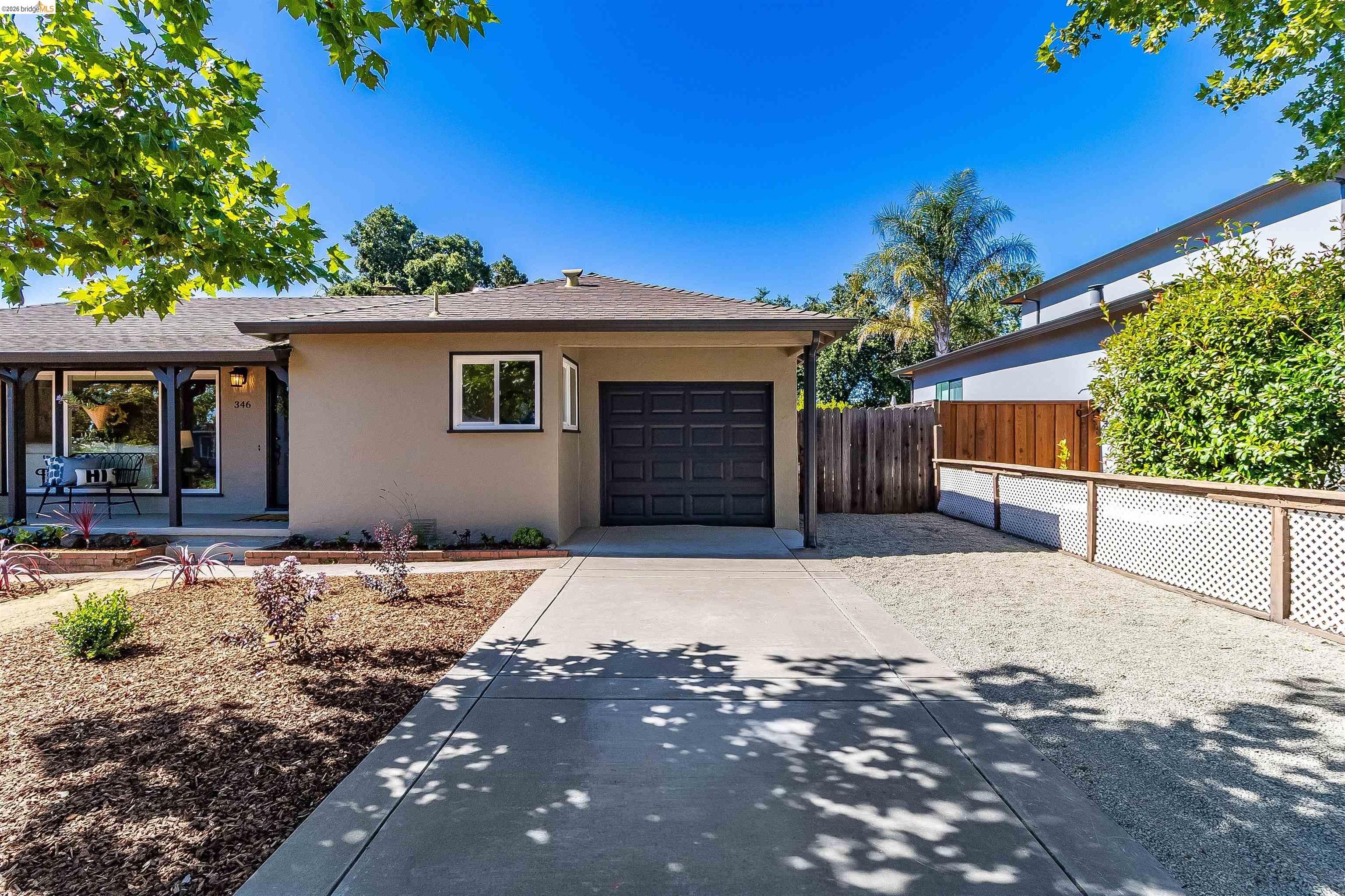 346 Valley View Road Pleasant Hill, CA 94523 - Photo 7 of 57 Single-story residence featuring a tan stucco exterior, dark brown garage door, and a covered porch entry