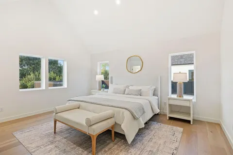 a bedroom with a bed a mirror and a window