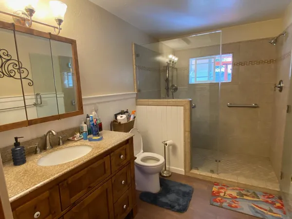 a bathroom with a granite countertop sink toilet and shower