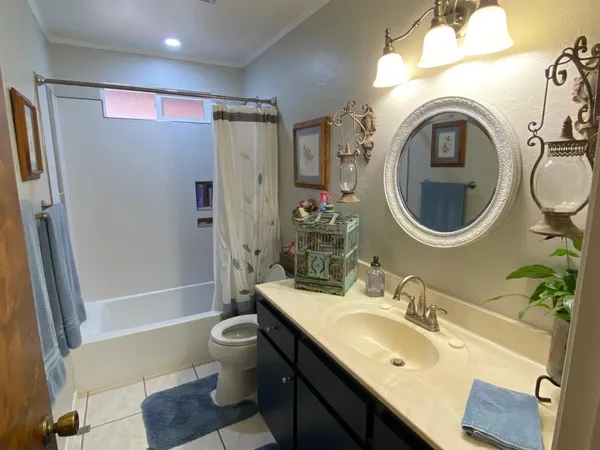 a bathroom with a granite countertop double vanity sink a mirror and a shower