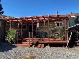 a view of a roof deck with table and chairs a barbeque with wooden fence and floor