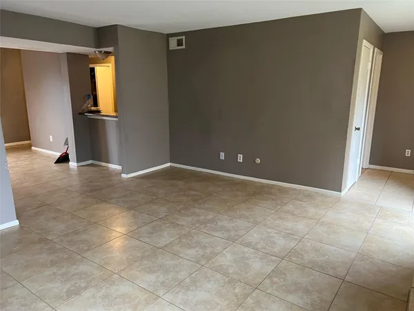 a view of empty room with wooden floor and window