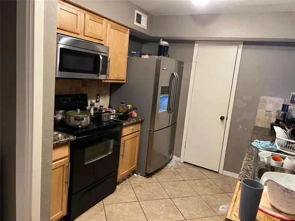a kitchen with stainless steel appliances granite countertop a refrigerator stove and microwave