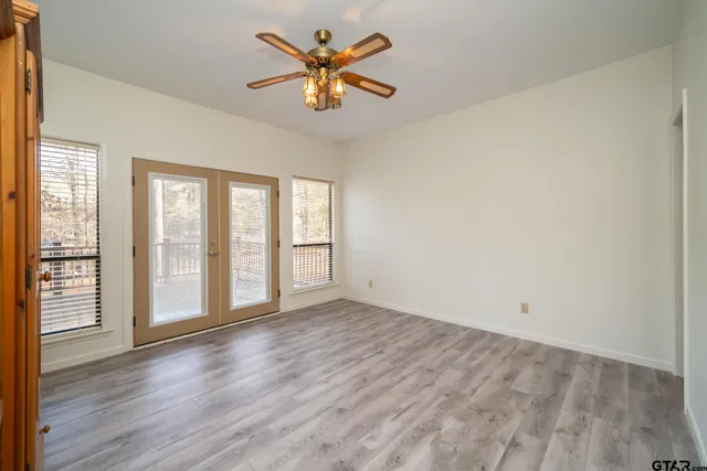 a view of an empty room with a window and wooden floor