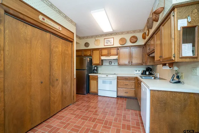 a kitchen with stainless steel appliances granite countertop a refrigerator and a stove top oven