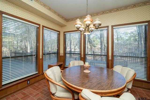 a dining room with furniture and large windows