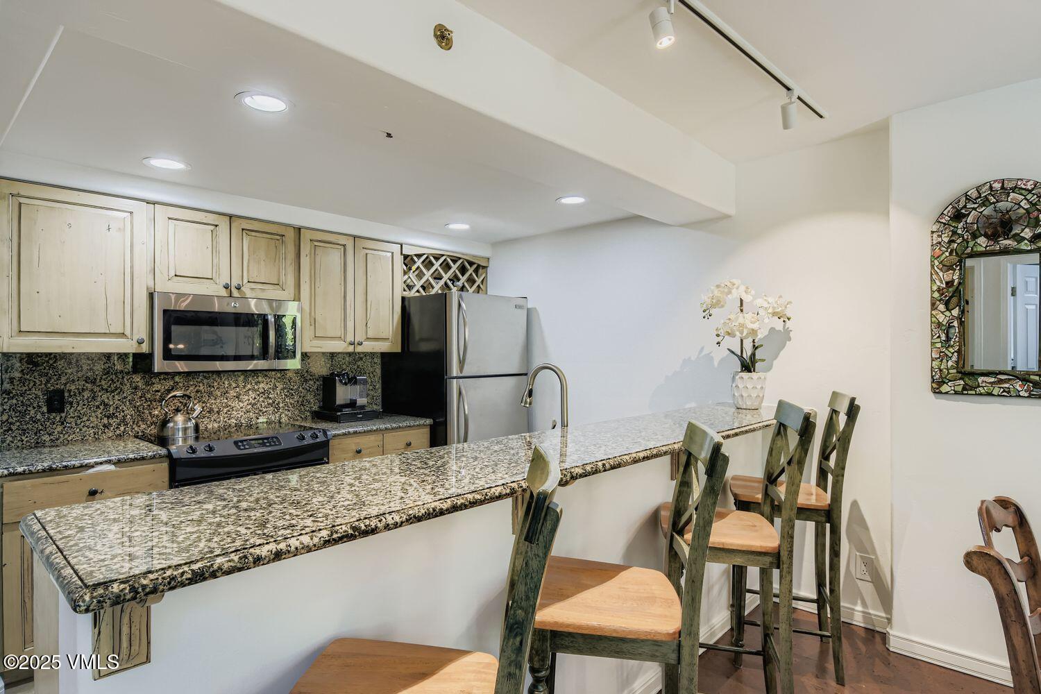 1120 Village Road, Unit 204 Beaver Creek, CO 81620 - Photo 11 of 29 a kitchen with stainless steel appliances granite countertop a sink refrigerator and microwave