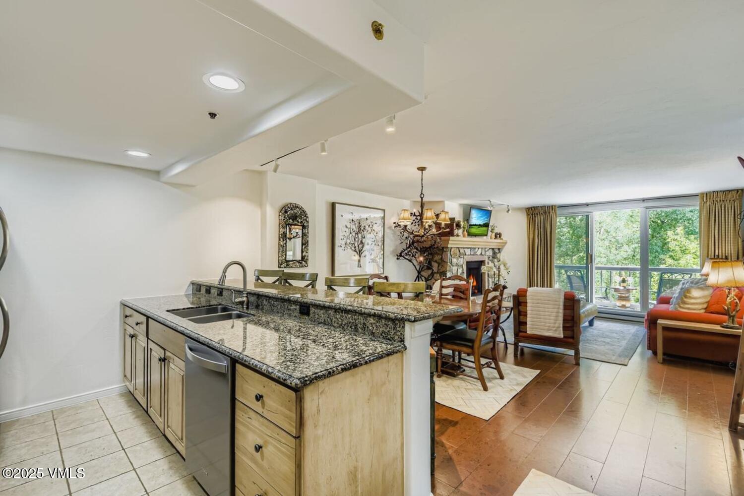 1120 Village Road, Unit 204 Beaver Creek, CO 81620 - Photo 9 of 29 a view of a kitchen with kitchen island stainless steel appliances a table and chairs in it