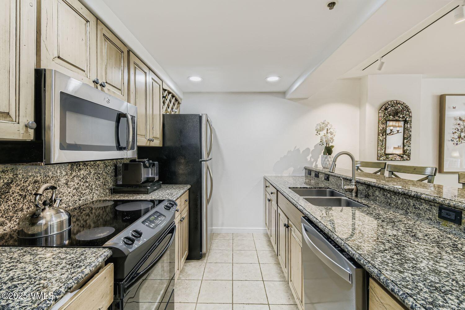 1120 Village Road, Unit 204 Beaver Creek, CO 81620 - Photo 10 of 29 a kitchen with stainless steel appliances granite countertop a sink stove and refrigerator