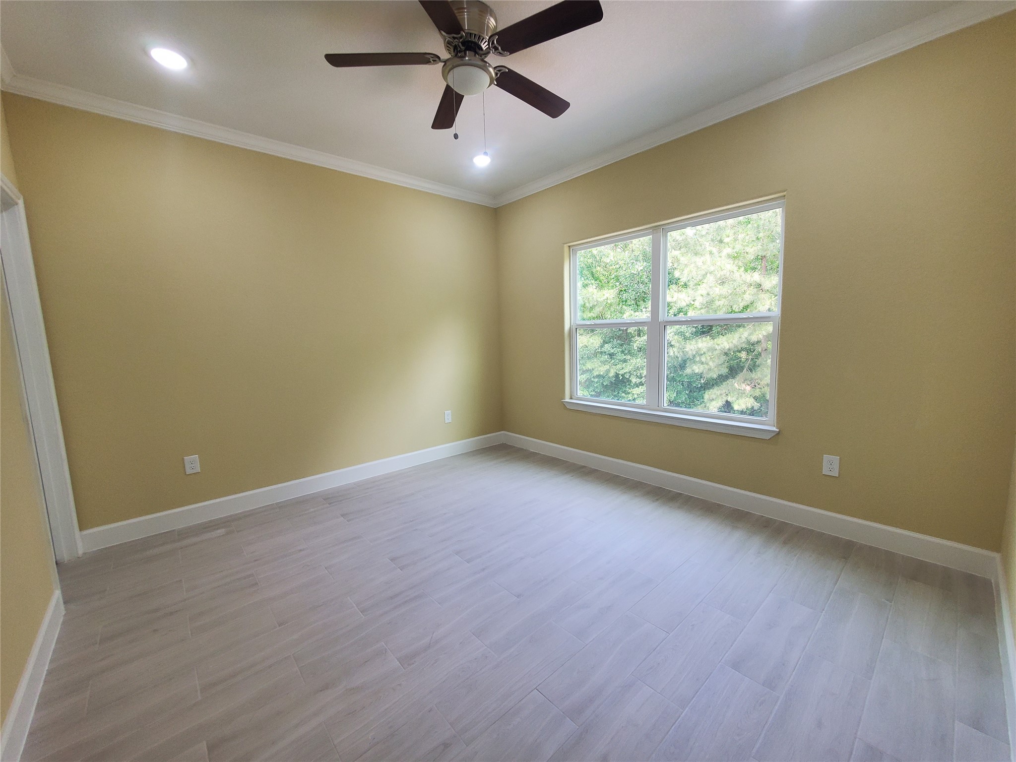1306 North 9th Street Conroe, TX 77301 - Photo 35 of 47 an empty room with a window and a fan