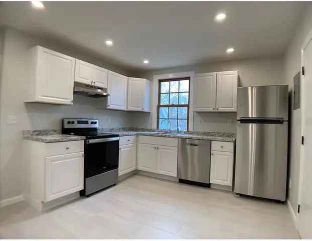 a kitchen with stainless steel appliances granite countertop a refrigerator sink and stove