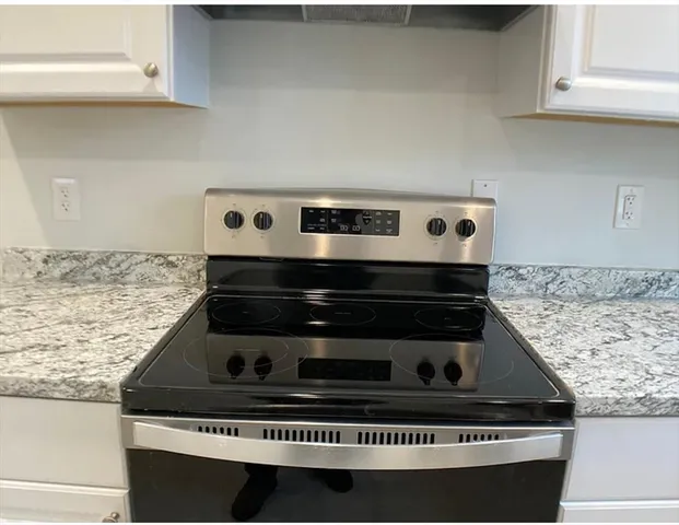 a stove top oven sitting inside of a kitchen