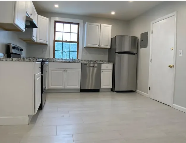 a kitchen with stainless steel appliances granite countertop a refrigerator sink and stove