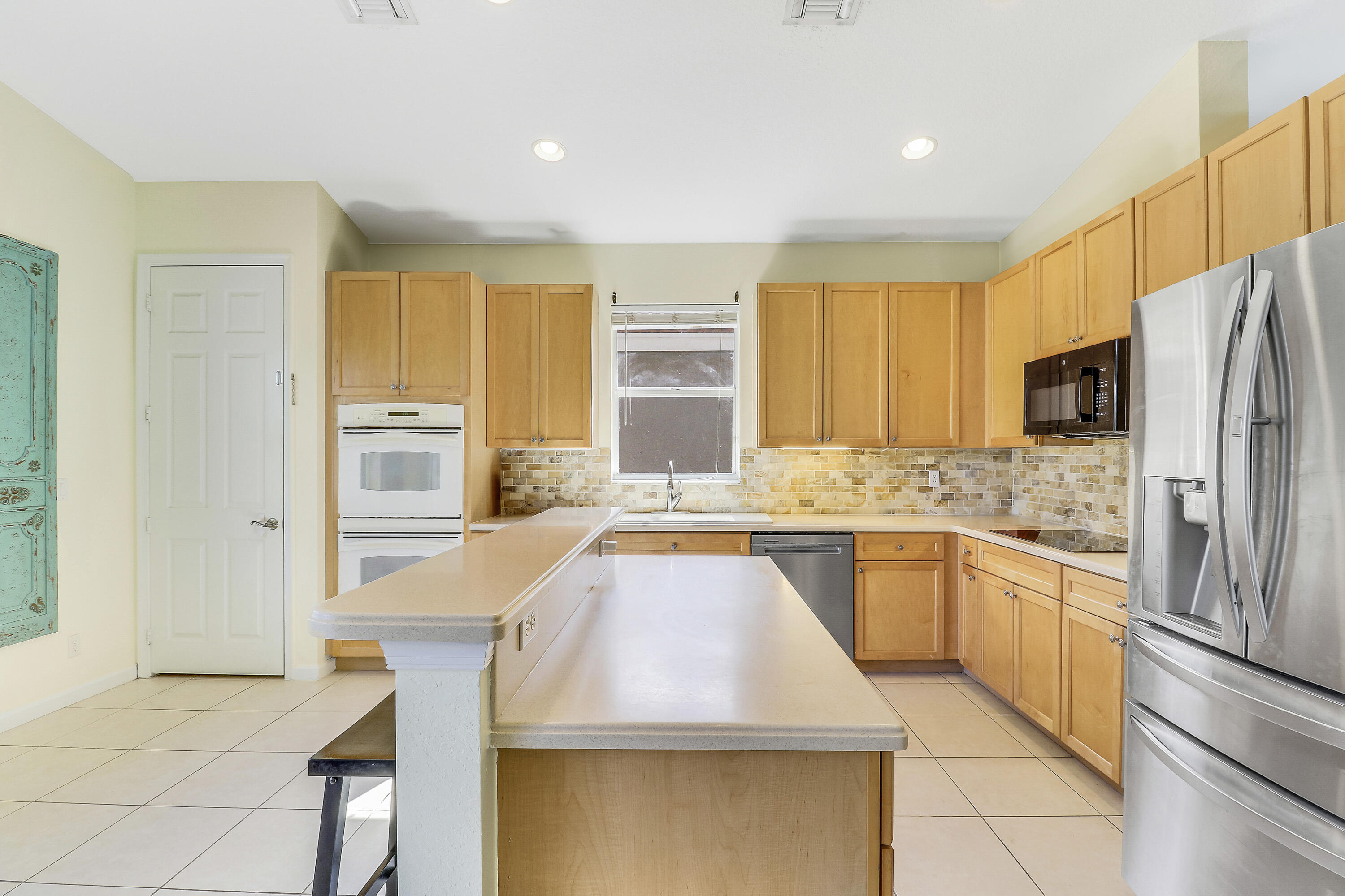5017 Southeast Graham Drive Stuart, FL 34997 - Photo 12 of 38 a kitchen with stainless steel appliances granite countertop a sink and a refrigerator