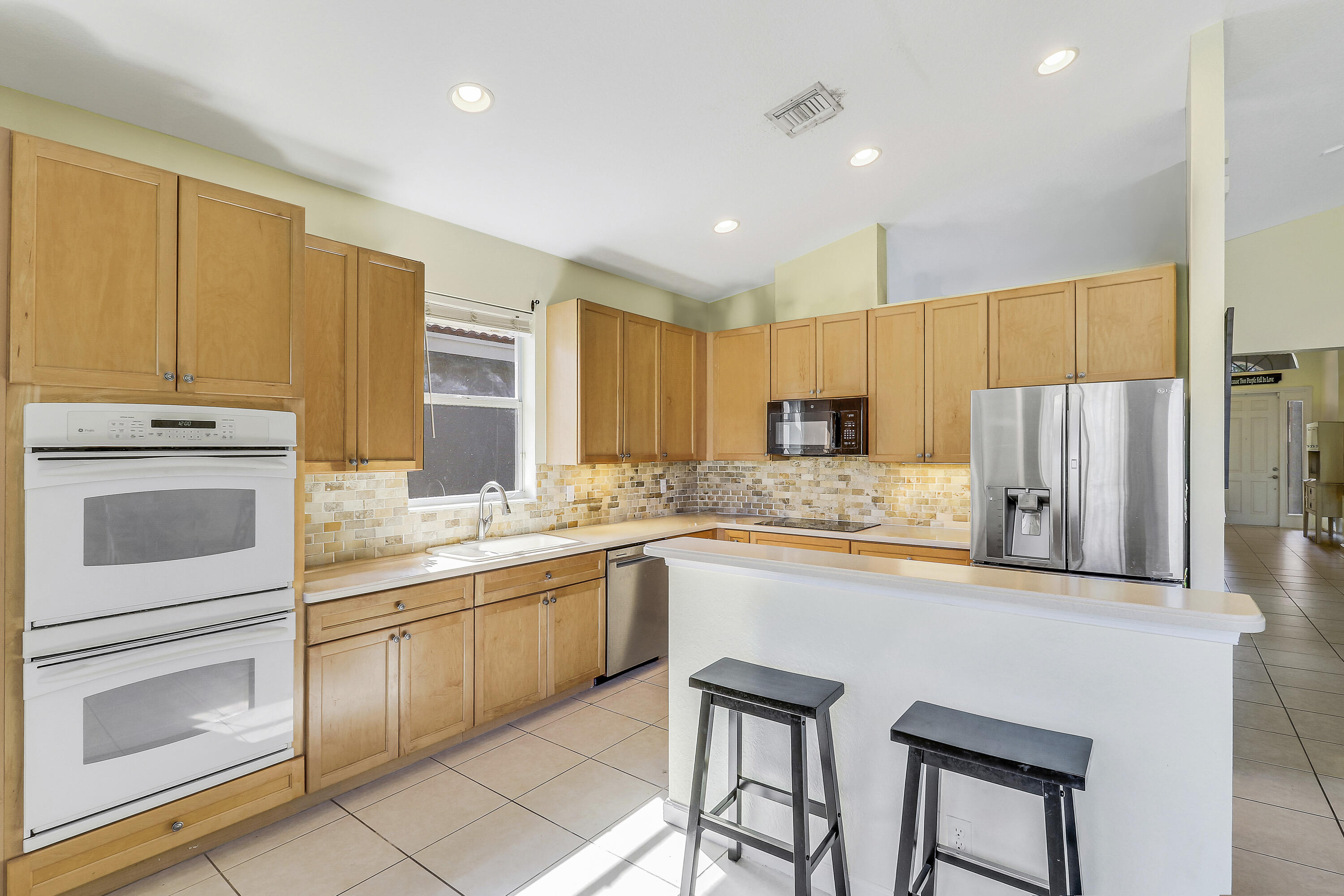 5017 Southeast Graham Drive Stuart, FL 34997 - Photo 15 of 38 a kitchen with stainless steel appliances granite countertop a stove a sink island and a refrigerator