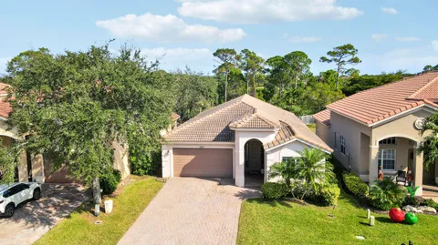 a front view of a house with a yard and potted plants