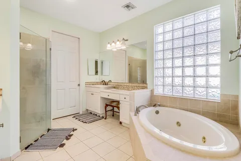 a bathroom with a tub sink and mirror