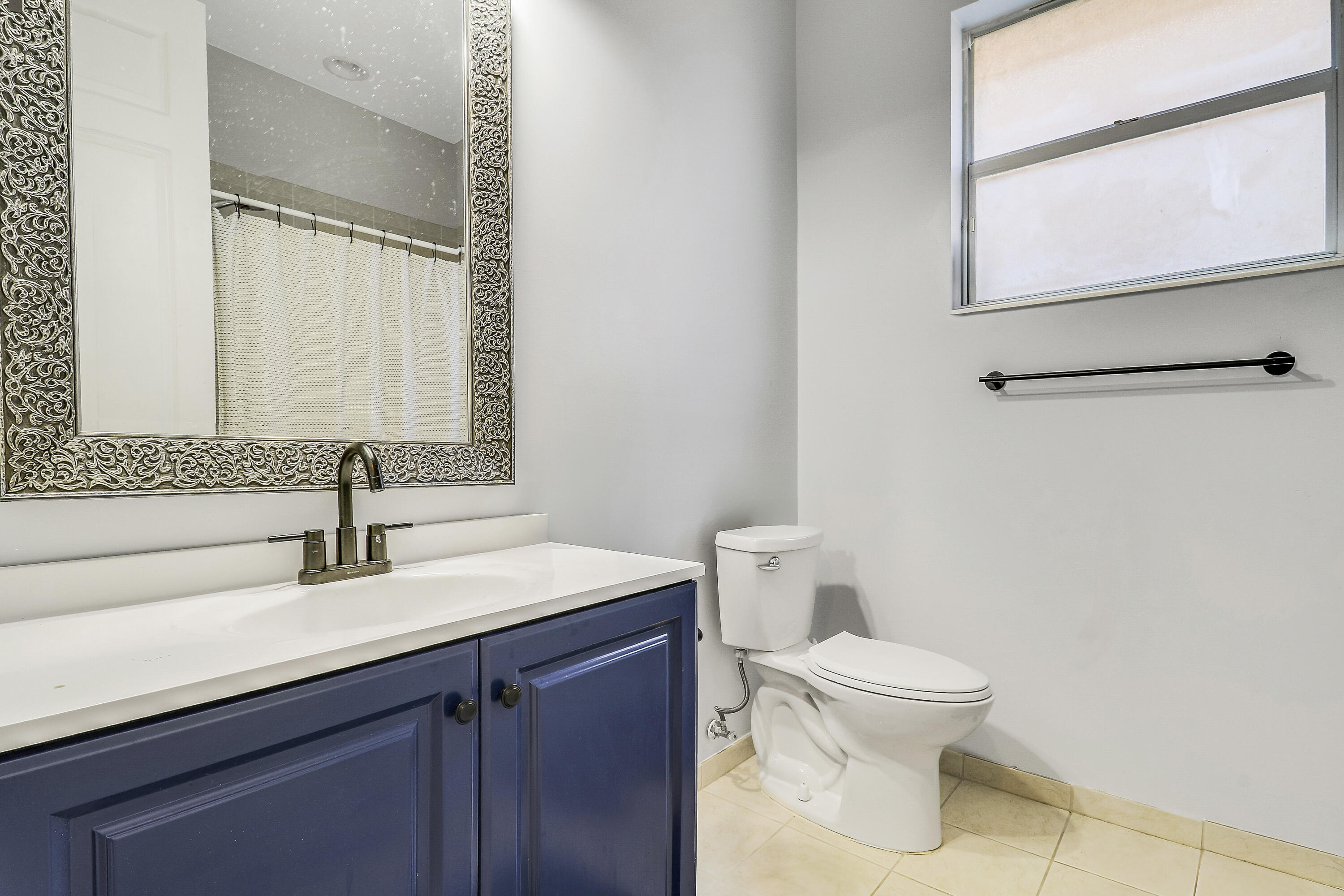 5017 Southeast Graham Drive Stuart, FL 34997 - Photo 25 of 38 a bathroom with a toilet sink and mirror