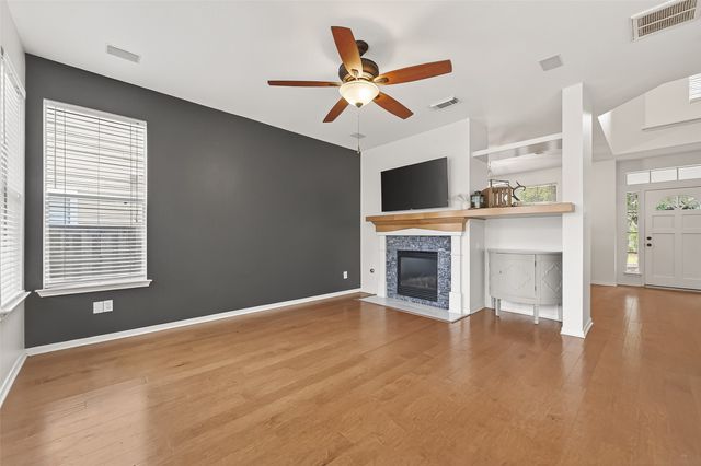 a view of an empty room with a fireplace and a window